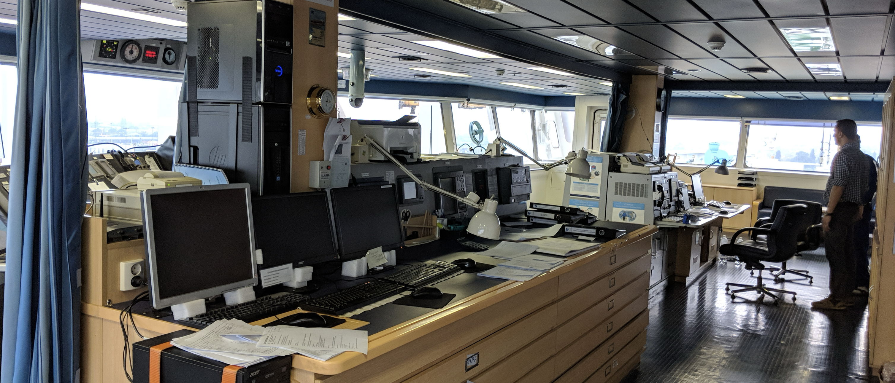 Ship's bridge and chart office, covered in printers, monitors and paper reports